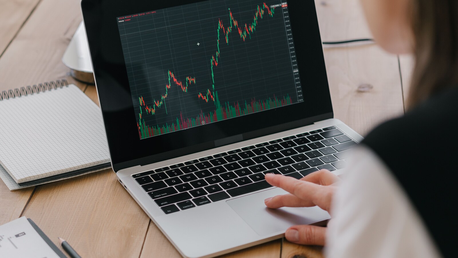 Pessoa acompanha gráfico do mercado financeiro em um notebook