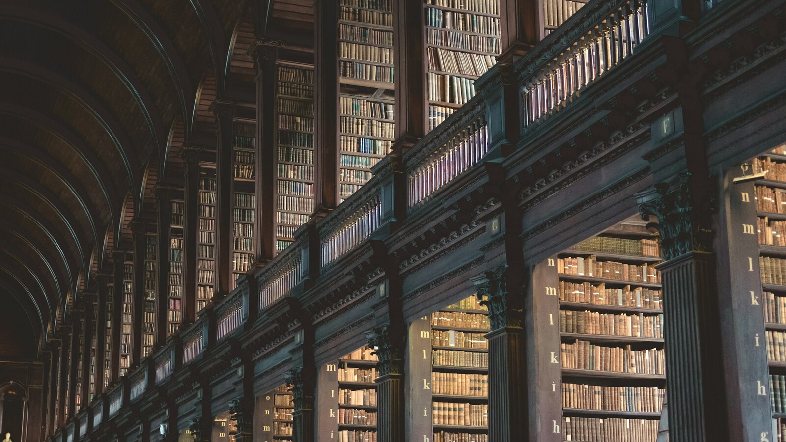 Estantes altas repletas de livros antigos em uma biblioteca