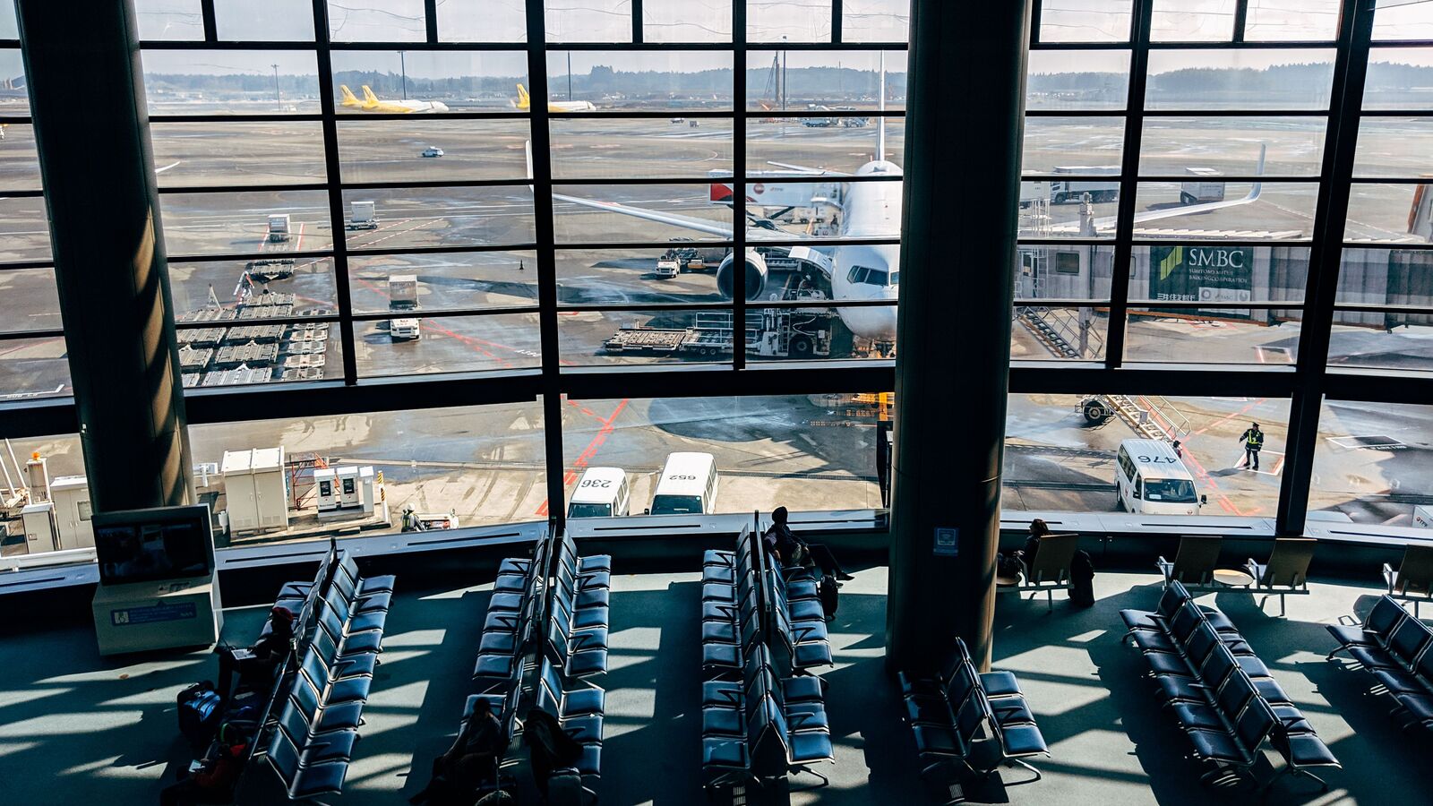 Sala de espera de aeroporto internacional vista diante das pistas