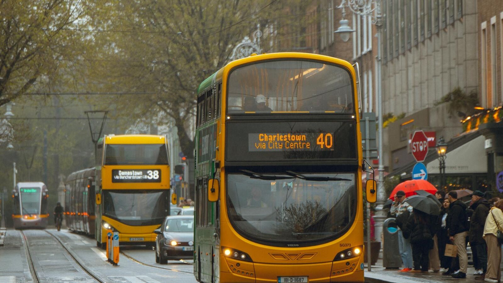 Ônibus de dois andares e passageiros em uma rua de Dublin