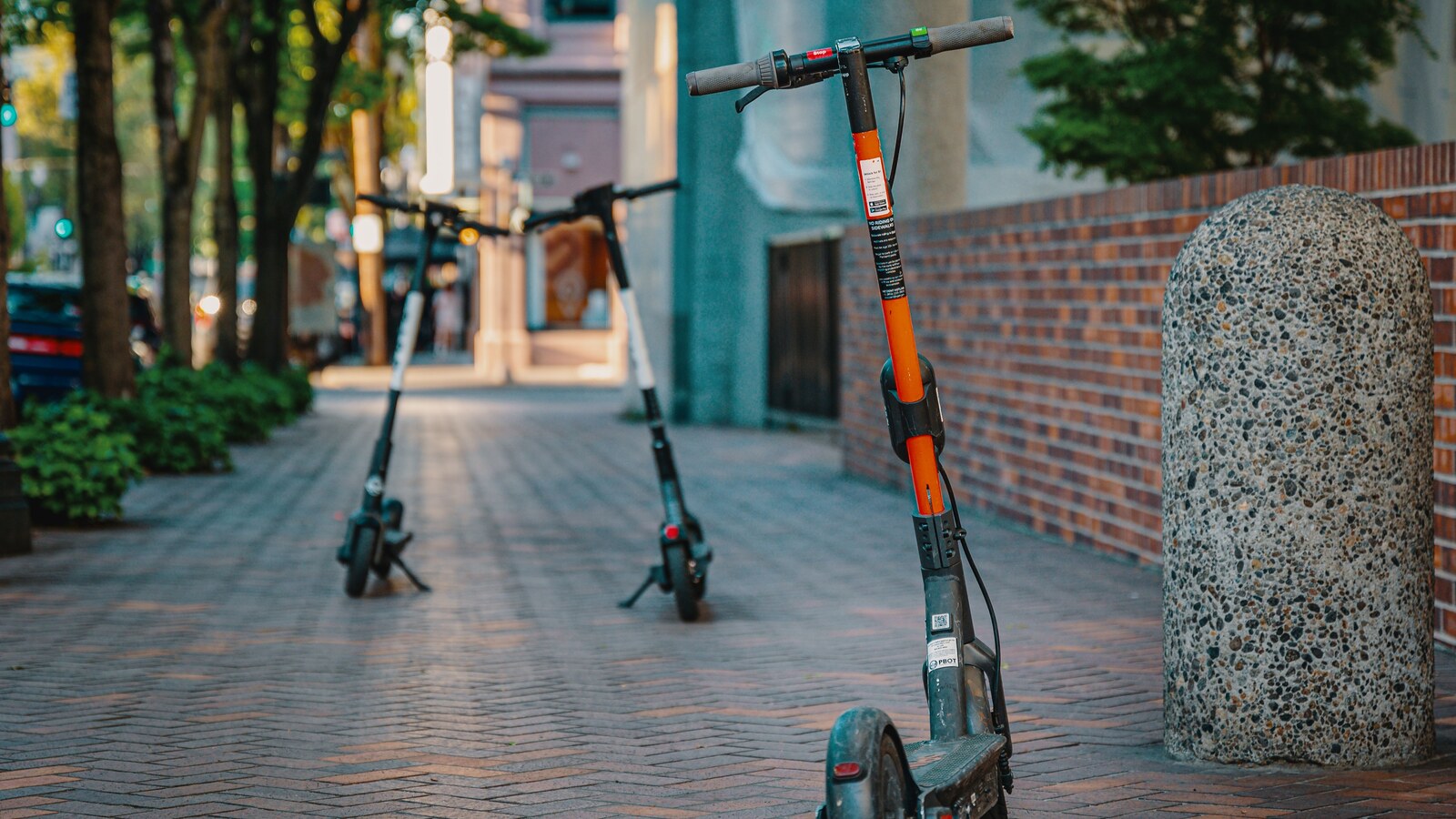 Patinetes elétricos estacionados em uma calçada urbana