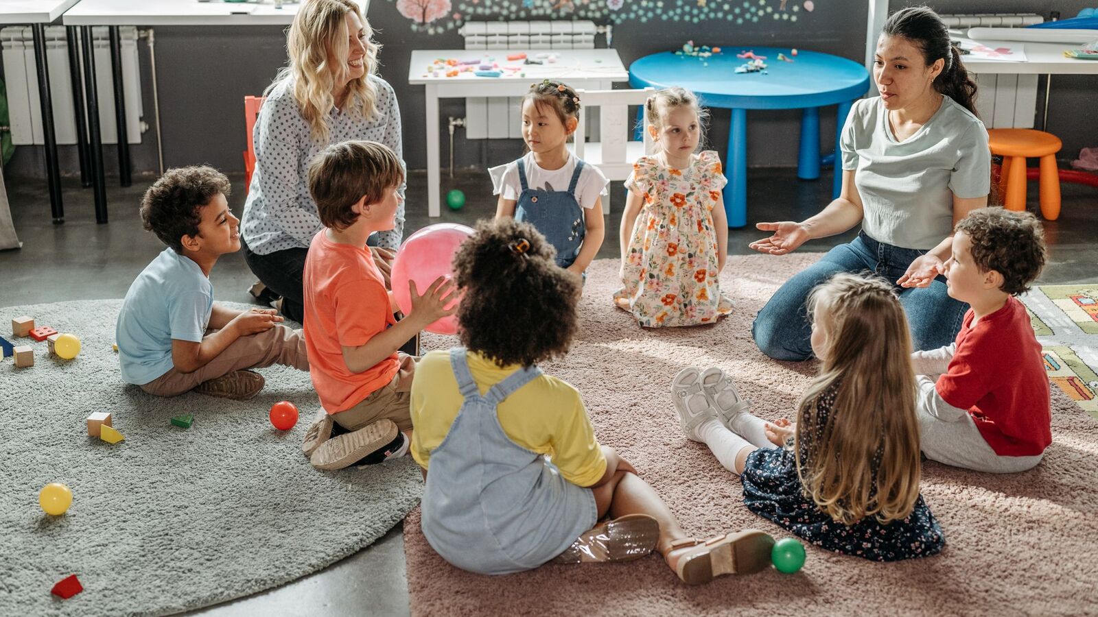 Crianças sentadas em roda com educadores dentro de uma creche