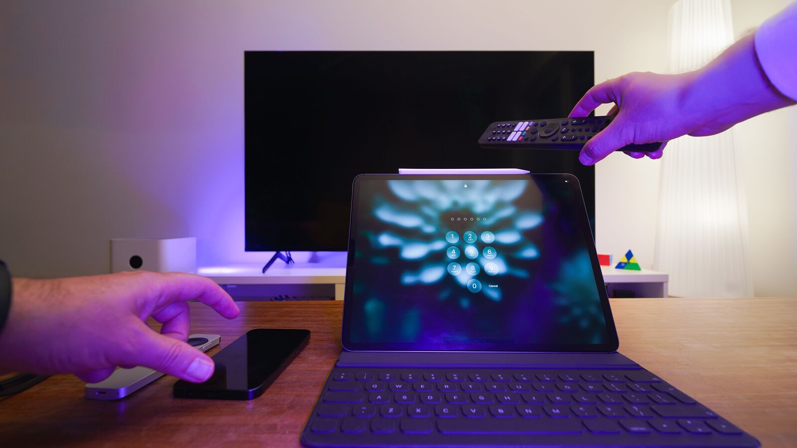 Televisão, tablet e controle remoto em uma sala