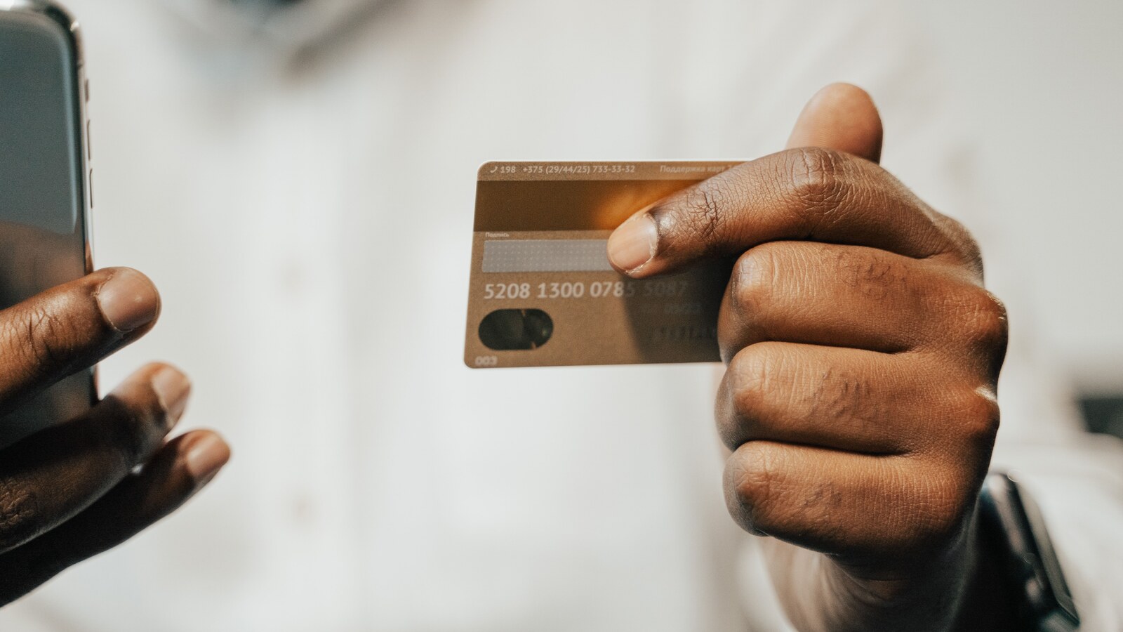 Pessoa usando cartão bancário e celular durante indisponibilidade dos serviços da Revolut